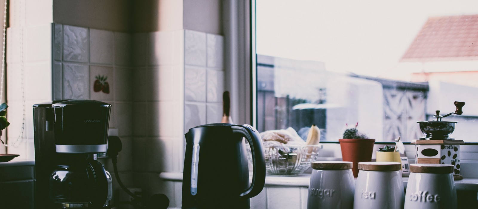 A tidy kitchen counter with one refillable spray bottle standing in for a cabinet full of products