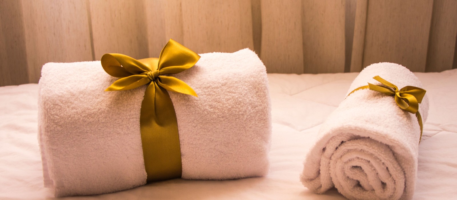 A bottle of fabric softener beside fresh towels on a laundry room counter